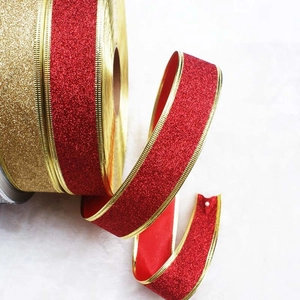 Close-up of sparkling red glitter ribbon with luxury gold edges for gift wrapping