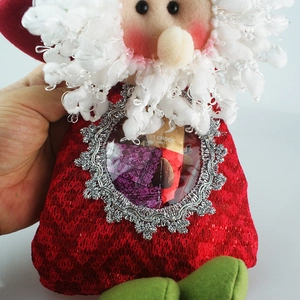 Detail of Santa candy bag with red mesh fabric and clear window showing chocolate inside