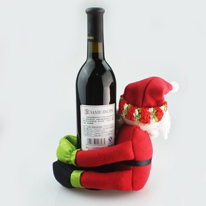 Detail of plush Santa Claus wine bottle cover with festive green gloves and shoes