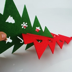 DIY felt Christmas tree tabletop decor in red and green with hollowed-out festive patterns