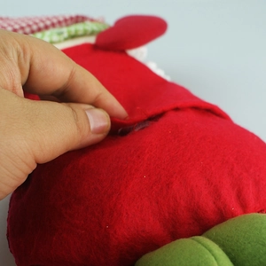 Detail of red and green felt Christmas candy bag showing the pocket opening and soft fabric