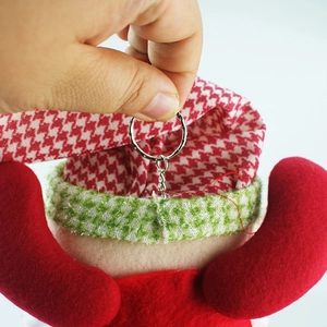 Detail of Christmas plush pendant with red houndstooth hat and silver keychain ring
