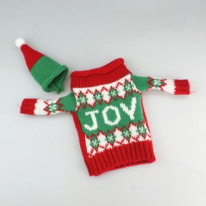 Detail of Christmas wine bottle cover featuring knitted green JOY sweater and red hat