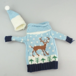 Detail of blue knitted Christmas wine bottle cover with reindeer and snowflake patterns