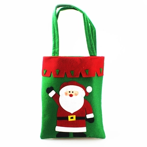 Close-up of green felt Christmas gift bag featuring a Santa Claus applique and red wavy trim
