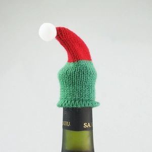 Detailed knitted Christmas wine bottle cap decoration in festive red and green with white pompom