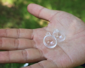 Dettaglio di piccole palline di Natale trasparenti tenute in mano per scala