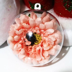 Dettaglio macro di un ornamento natalizio in acrilico trasparente con fiore rosa interno