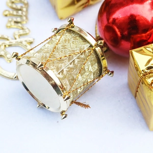 Festive Christmas tree decoration with golden drum ornaments and red baubles in PVC box