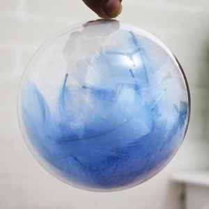 Pallina di Natale trasparente vuota riempita con piume blu decorative