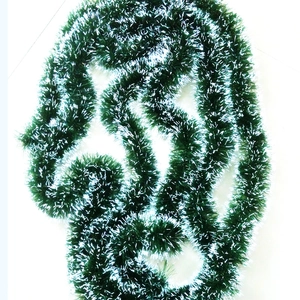 Detail of 2m dark green Christmas tinsel garland with white tips for tree decoration
