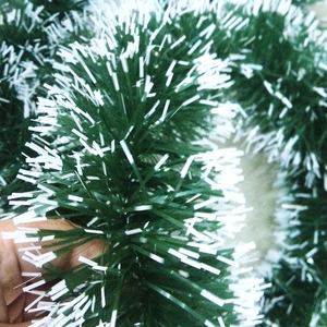 Close-up of 2m dark green Christmas garland with white snowy tips for festive tree decoration