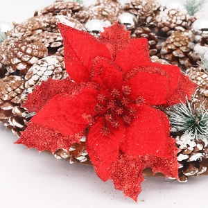 Macro detail of a 15cm red glitter poinsettia flower on a pine cone Christmas wreath