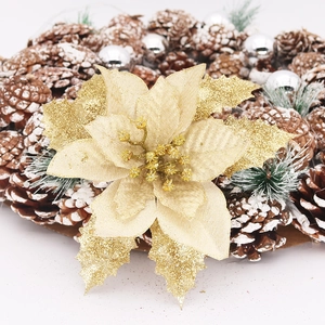 Macro shot of 15cm gold glitter poinsettia with snowy pine cones and silver baubles