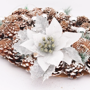 Close-up of artificial silver poinsettia with glittery pine cones and LED lights