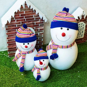 Three-piece snowman set with striped hats and scarves in a miniature winter garden