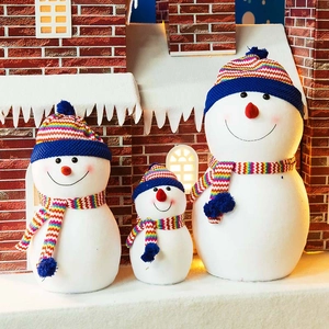 Set of 3 decorative Christmas snowmen with rainbow knit hats and scarves on snow
