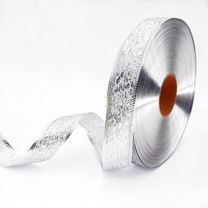 Macro detail of silver Christmas ribbon with frosted texture and embossed dot edges