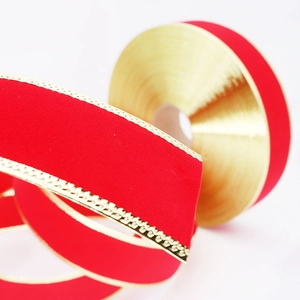 Red velvet Christmas ribbon with gold edges on a roll for tree decoration and gift wrapping