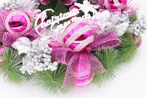 Close-up of pink Christmas wreath with silver pine needles and Christmas Greetings sign