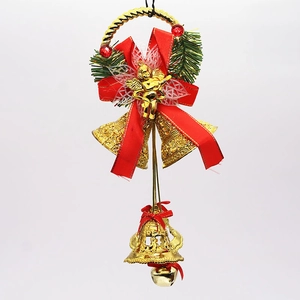 Detail of Christmas bell ornament with gold angel, red bow, and pine needles
