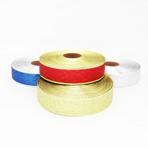 Dettaglio di nastri natalizi metallici con texture a rombi in rosso oro e argento lucido