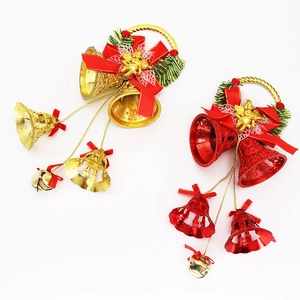 Detail of red and gold Christmas bell ornaments with ribbon bows and pine accents