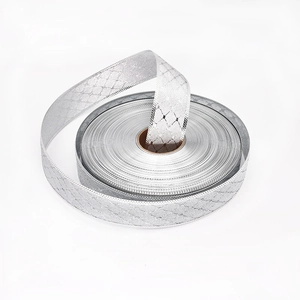Dettaglio di un rotolo di nastro argento metallizzato con trama a rombi per pacchi regalo