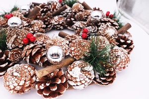 Detailed close-up of 37cm white pine cone Christmas wreath with red berries and LED lights