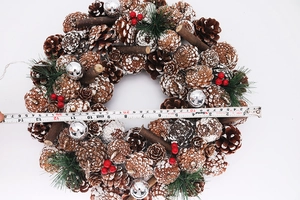 Detailed view of 37cm white pine cone Christmas wreath with LED lights and red berries