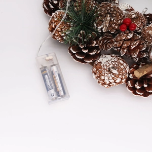 Detail of pine cone Christmas wreath with LED lights and a clear battery compartment