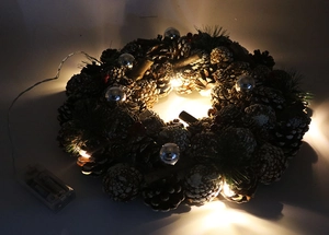 Detail of 37cm white pine cone Christmas wreath with warm LED lights and red berries