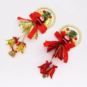 Detail of red and gold Christmas bell ornaments with Santa dolls and pine branches