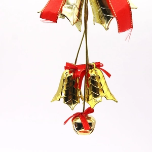 Detailed view of red ribbon bow and gold bells for Christmas tree hanging decoration