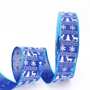 Blue Christmas ribbon with white reindeer and snowflake prints for holiday gift wrapping