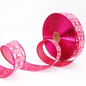 Detail of hot pink Christmas ribbon with white reindeer and snowflake prints