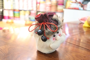 Detail of Christmas gift bag with Santa face, lamb wool base, and red drawstring bells