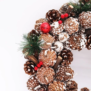 Détail d'une couronne de Noël de 37 cm avec pommes de pin givrées et baies rouges