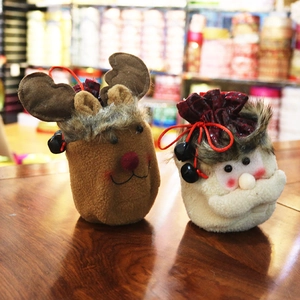 Detail of handmade Christmas gift bags with reindeer and Santa designs and bells