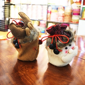 Detail of plush Christmas gift bags featuring reindeer and Santa Claus with drawstrings
