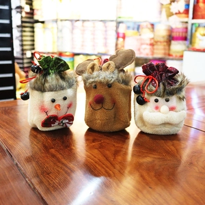 Detail of plush Christmas gift bags with Santa, reindeer, and snowman drawstring designs
