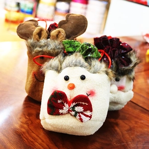 Close-up of handmade Christmas drawstring gift bags with plush Santa and snowman designs