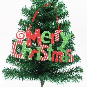 Glittery Merry Christmas lettering sign with red ribbon hanging on green tree branch