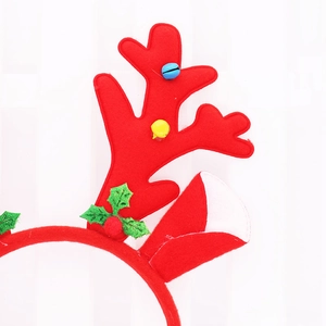 Christmas reindeer headband with red antlers, bells, and holly leaves on white background