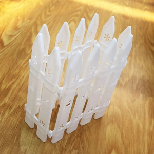 Detail of white plastic Christmas fence featuring snowflake and reindeer cutouts