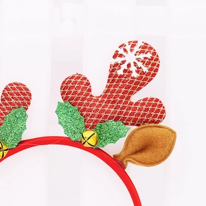 Detail of reindeer headband featuring red glitter antlers, holly leaves and gold bells