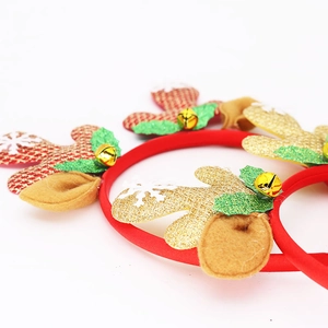 Christmas headband with gold and red sequined antlers and bell on a white background