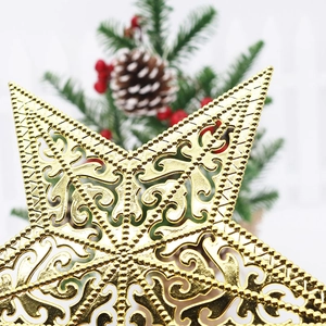 Macro detail of golden hollow-out star topper with intricate patterns on a Christmas tree