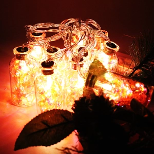 Close-up of LED glass wishing bottles with corks and sequins for Christmas decor