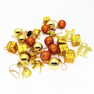 Close-up of golden Christmas ornaments including glitter balls, bells, and mini gift boxes